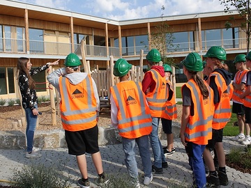 Bauleiterin Vera Engelhaft mit den Schüler auf der  Baustelle der neuen Kindertagesstätte am Biberacher Hauderboschen.